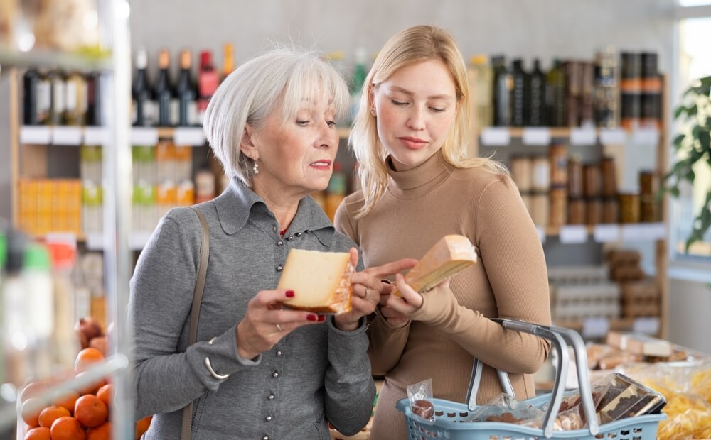 Mati in hči preverjata oznake na izdelkih v trgovini 